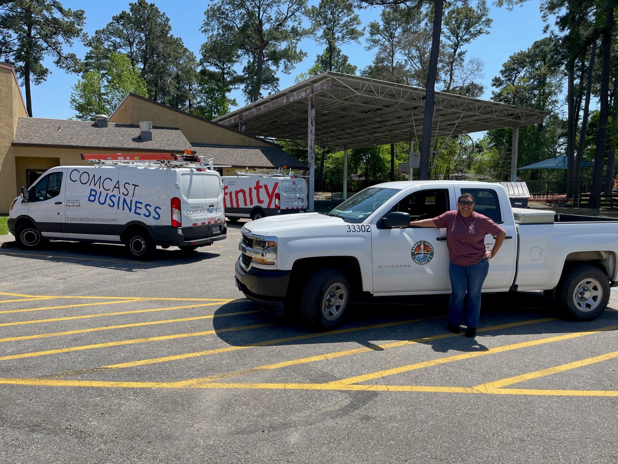 An Xfinity technician stands in front of a work truck.