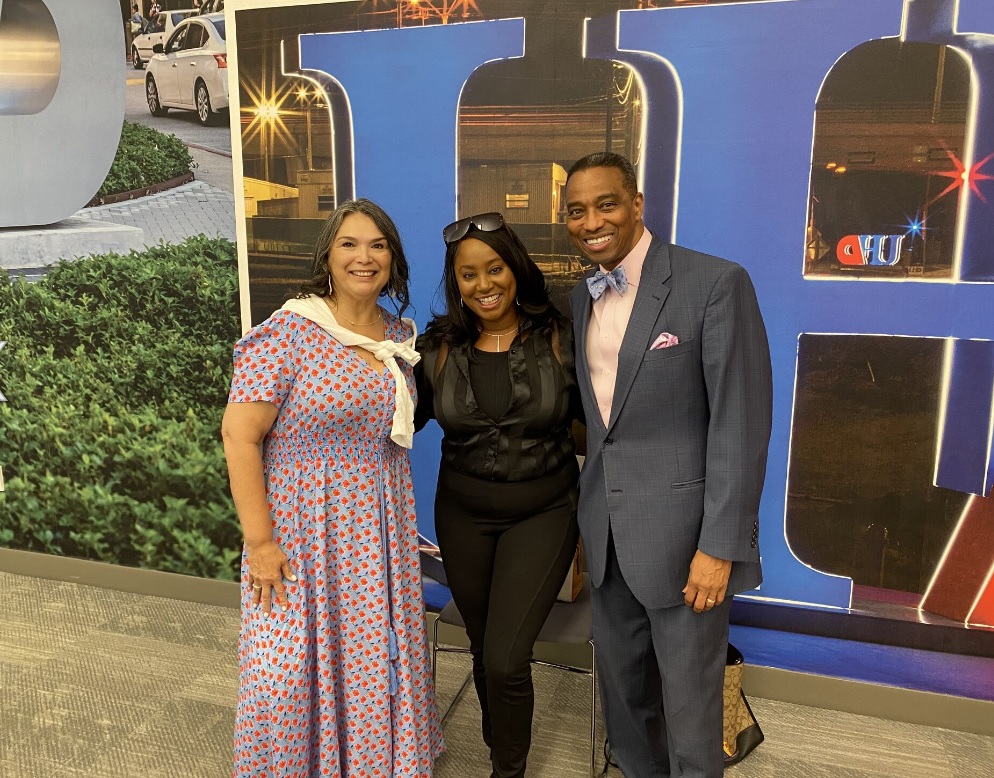 Three people standing together and posing for picture