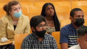 Four students seated and looking up at speaker