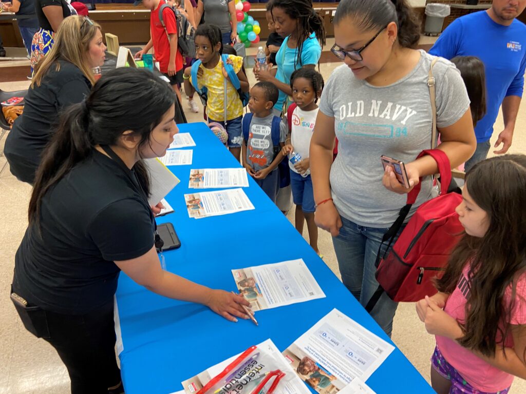 Volunteers showing guests Internet Essentials information