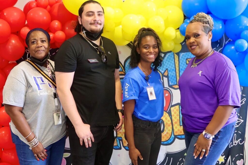 A group of people posing in front of colorful balloons for a picture