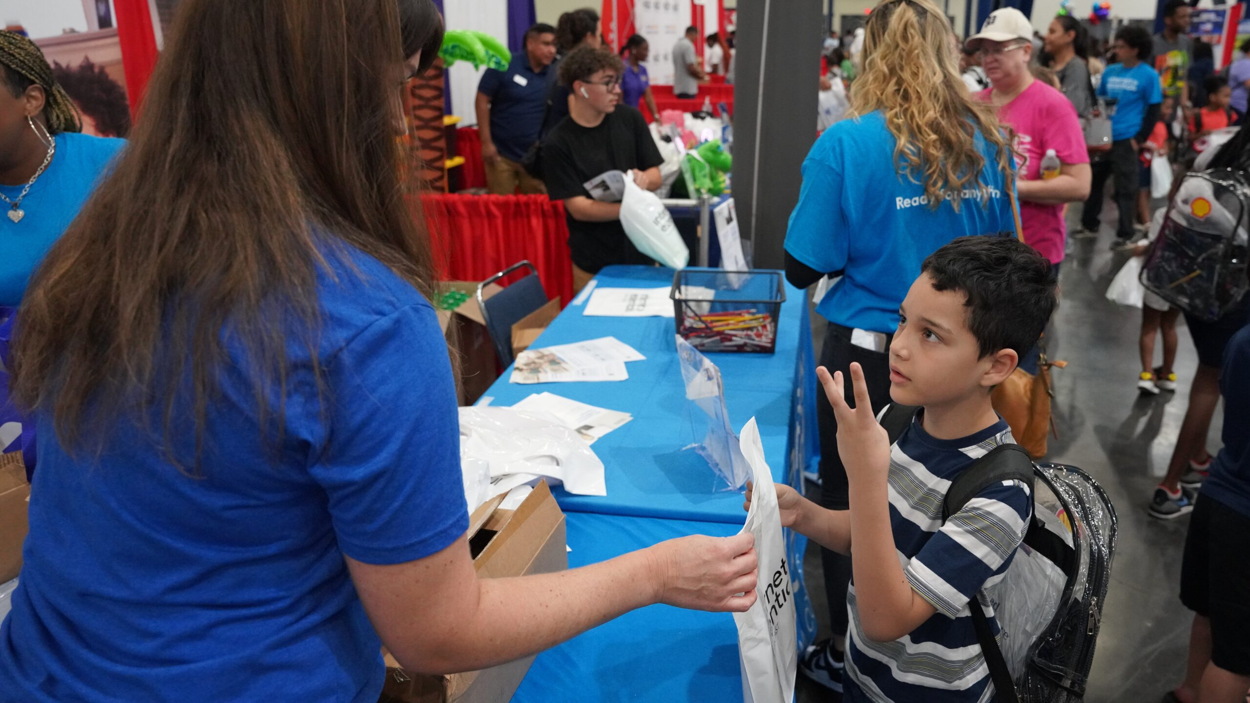 Young boy receiving bag from volunteer