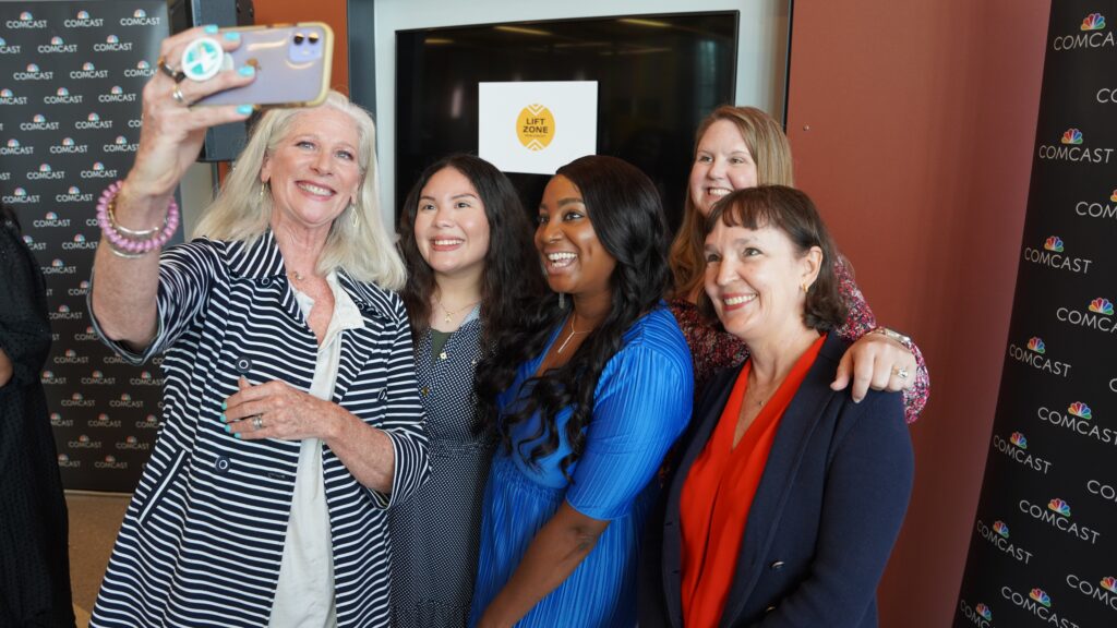 Five women smiling and posing for a selfie