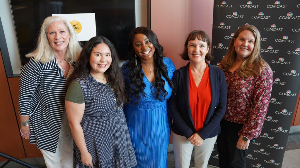 Five women smiling an posing for a picture together