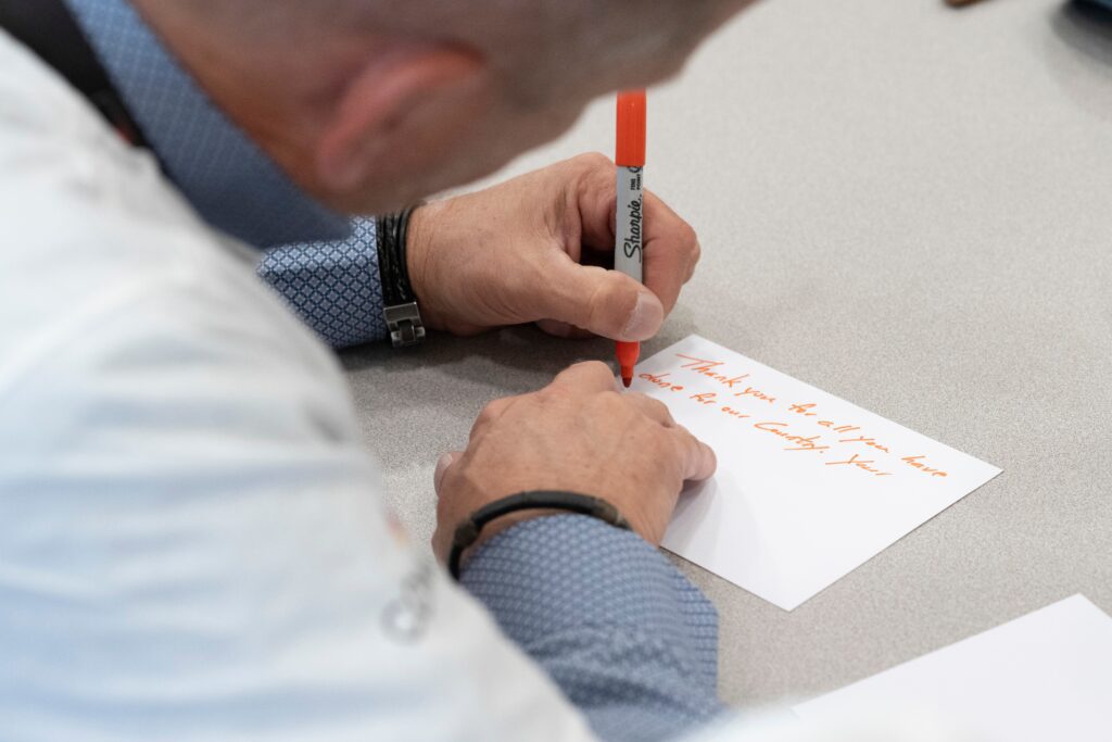 Close up of gentleman writing thank you note in red marker