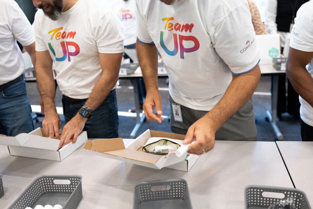 Two volunteers adding items to small boxes