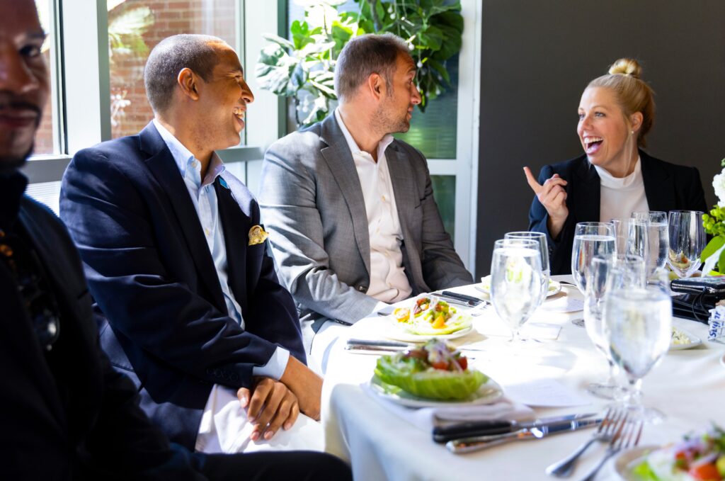 four people sitting at a set table chatting