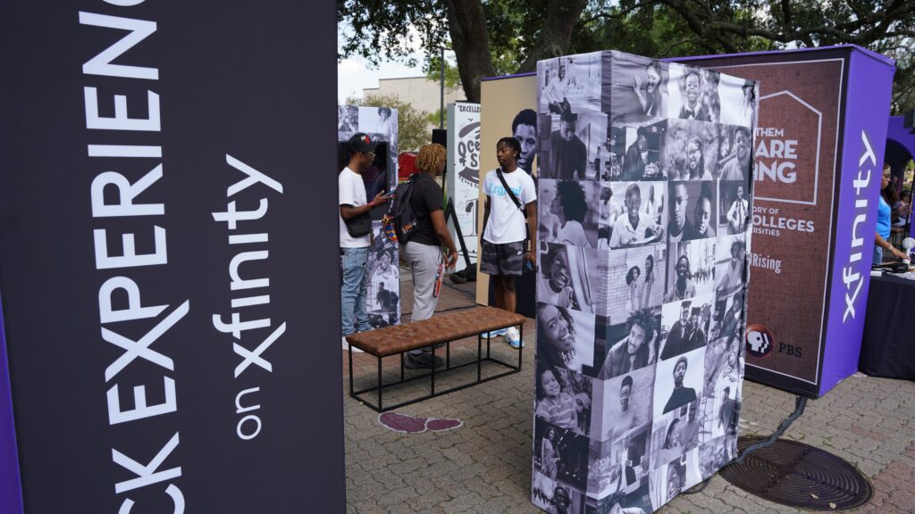 Multiple Xfinity signs with students milling around in background