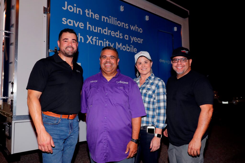 Four people smiling and standing together to posed for a picture.