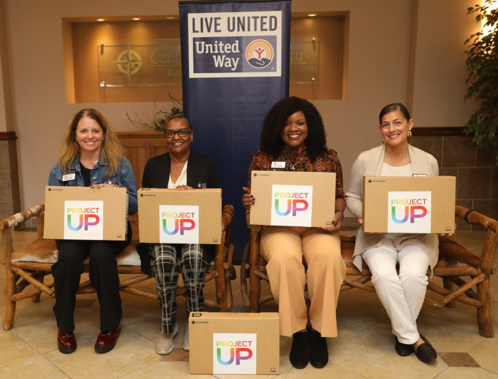 Four women seated and holding Project Up boxes