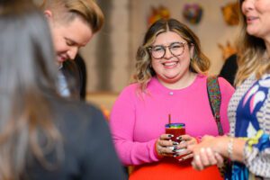 Woman in pink shirt and glasses with bright smile