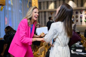 Two women laughing at event