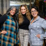 Three women smiling and posing for a picture