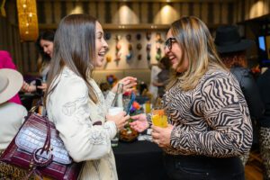 Two women smiling and chatting holding beverages