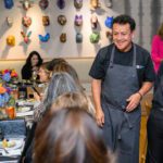 Chef Ortega smiling and looking at table of guests