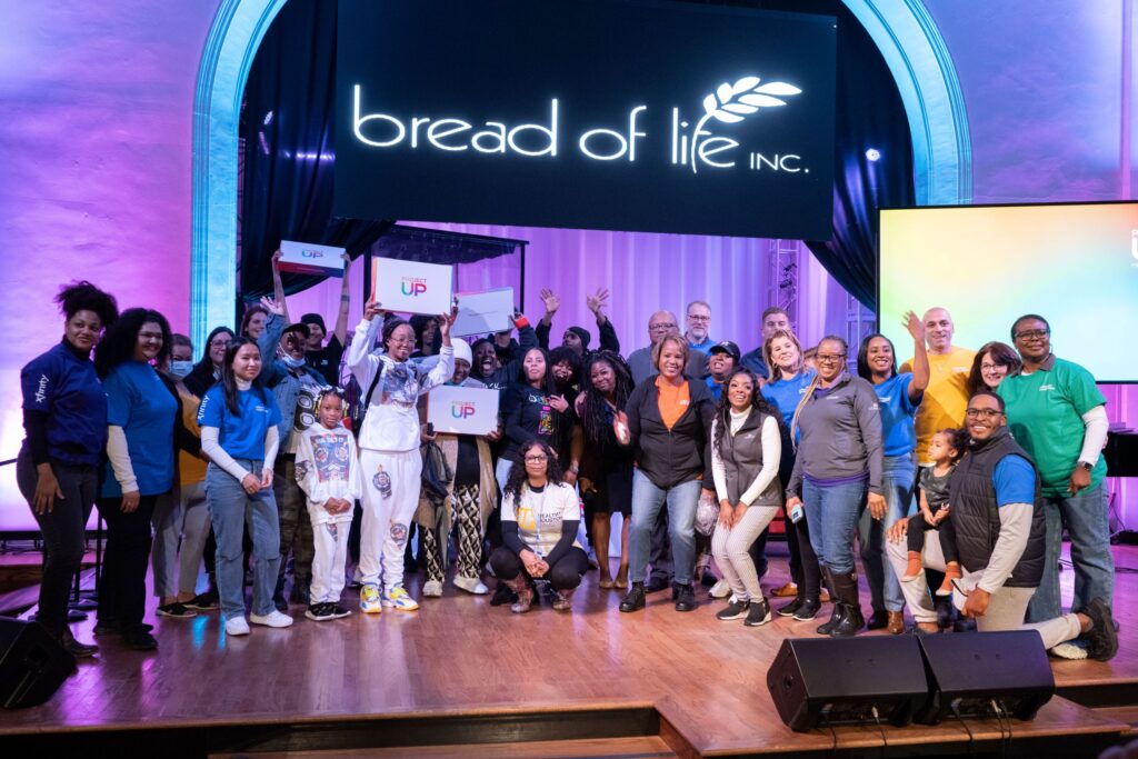 Crowd of people posing for photo on event stage.