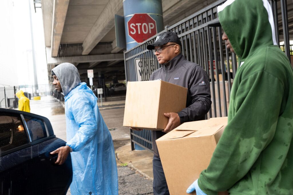 Broderick Johnson carrying large box to a car