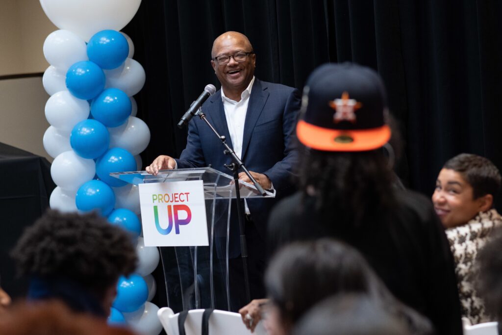 Smiling Broderick Johnson answering attendee question from podium.