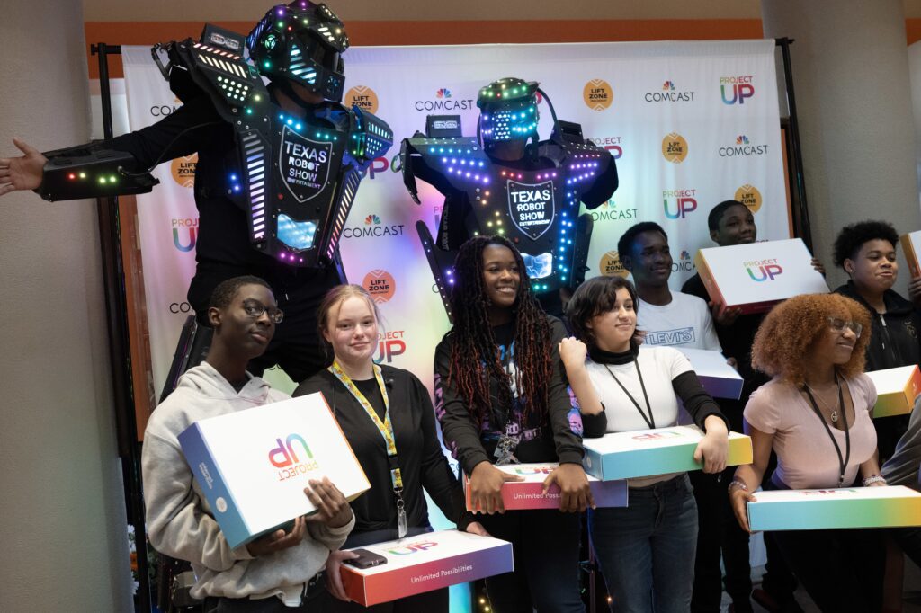 Smiling young adults holding Team Up boxes 