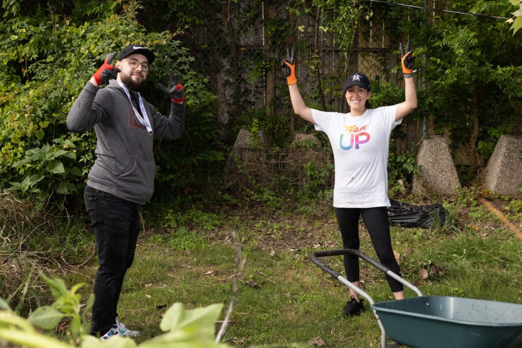 Two volunteers smiling with hands raised