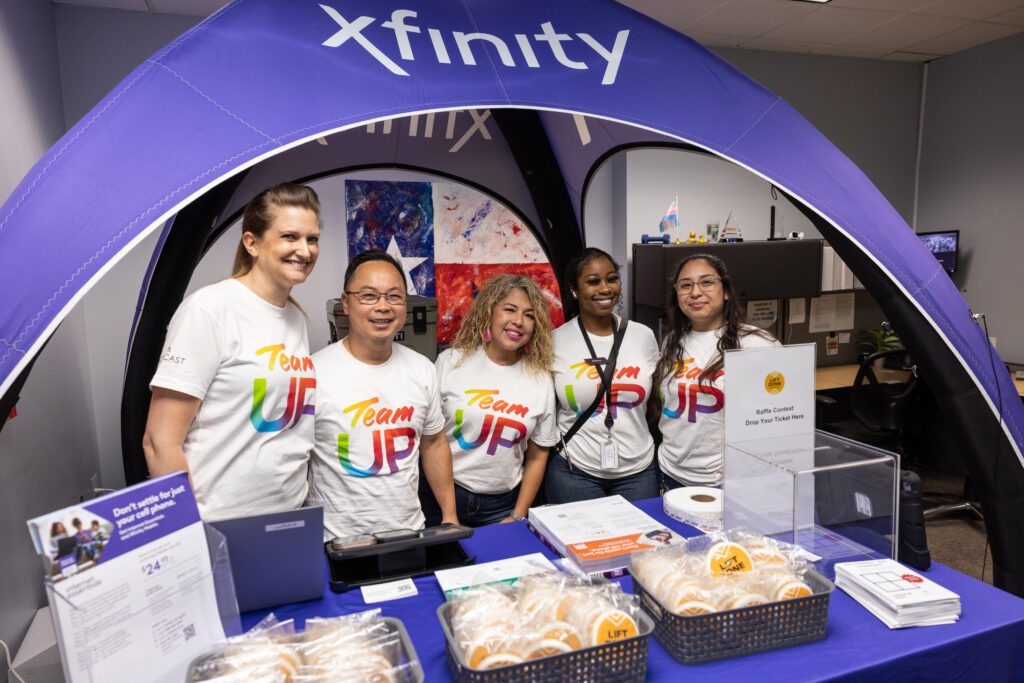 Team Up Volunteers posing for a picture behind a gift table