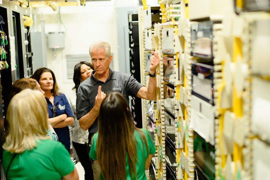 Technician giving tour of server room to guests.