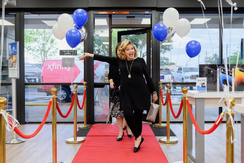 People walking into door of store and down a red carpet.