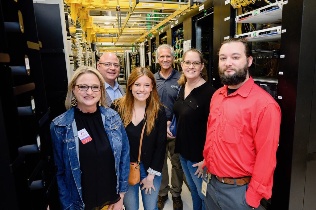 Tour guests posing for picture in server room.