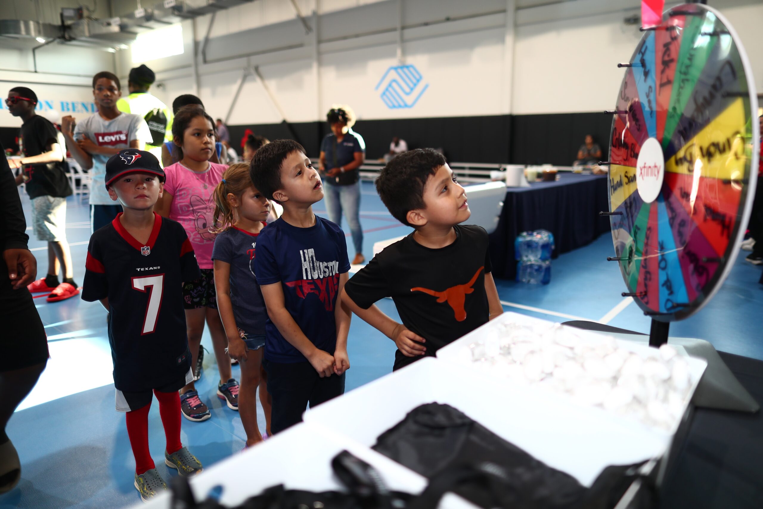 Kids playing a game at Xfinity booth table.