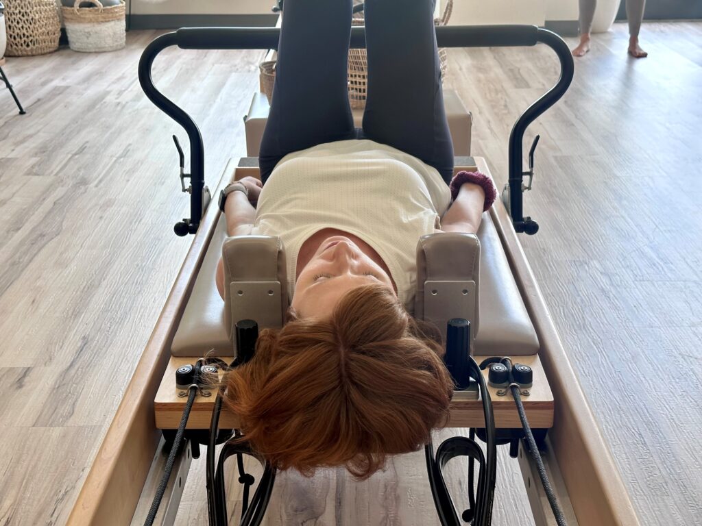 Woman laying on pilates table in studio