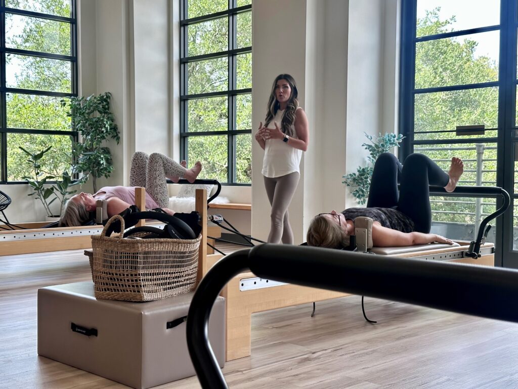 Two women receiving pilates instruction