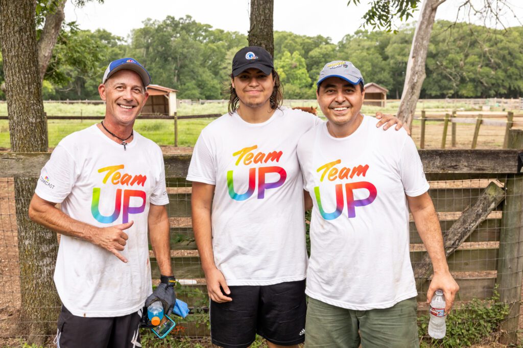 Three Team Up volunteers smiling and posing for a picture