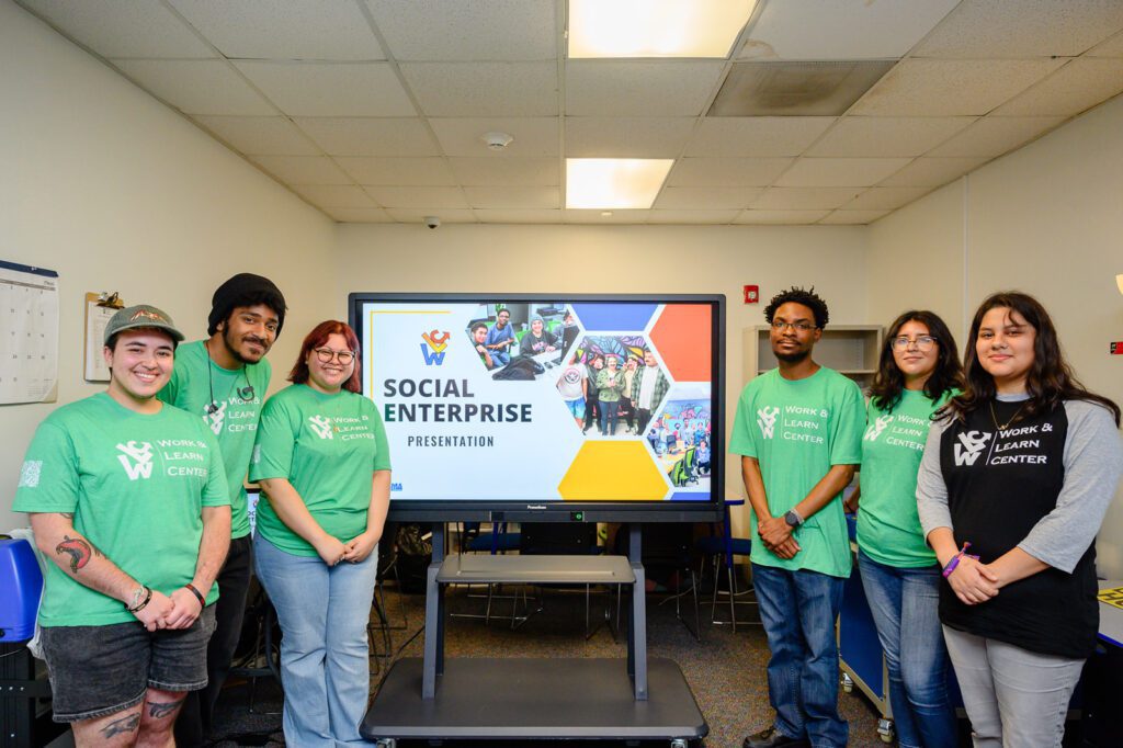 Students gather in front of a presentation board.