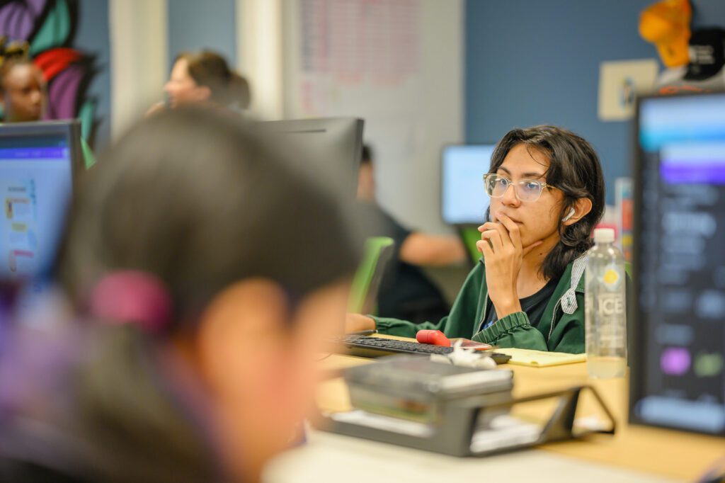 A student works at a computer inside the Work and Learn Center