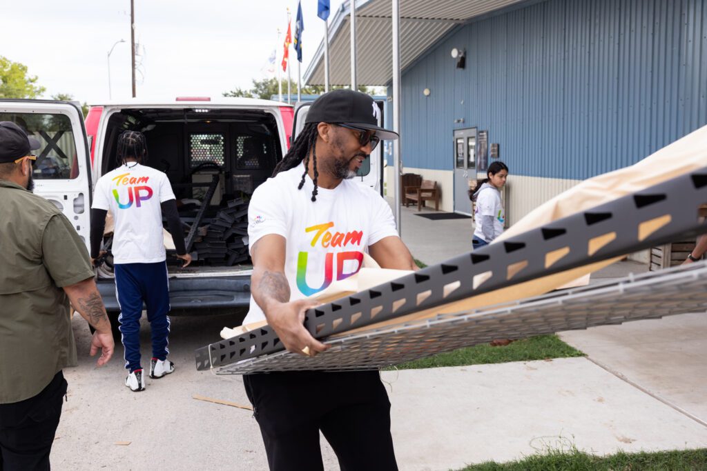 A volunteer moves a piece of shelving into Camp Hope in Houston, Texas.