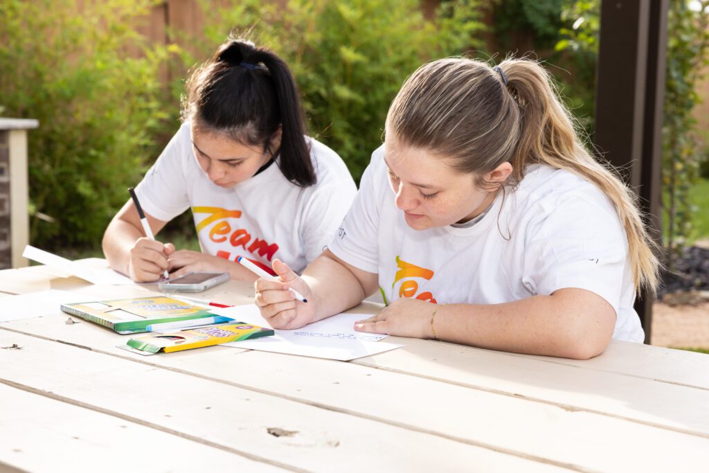 Volunteers write cards for veterans at Camp Hope.