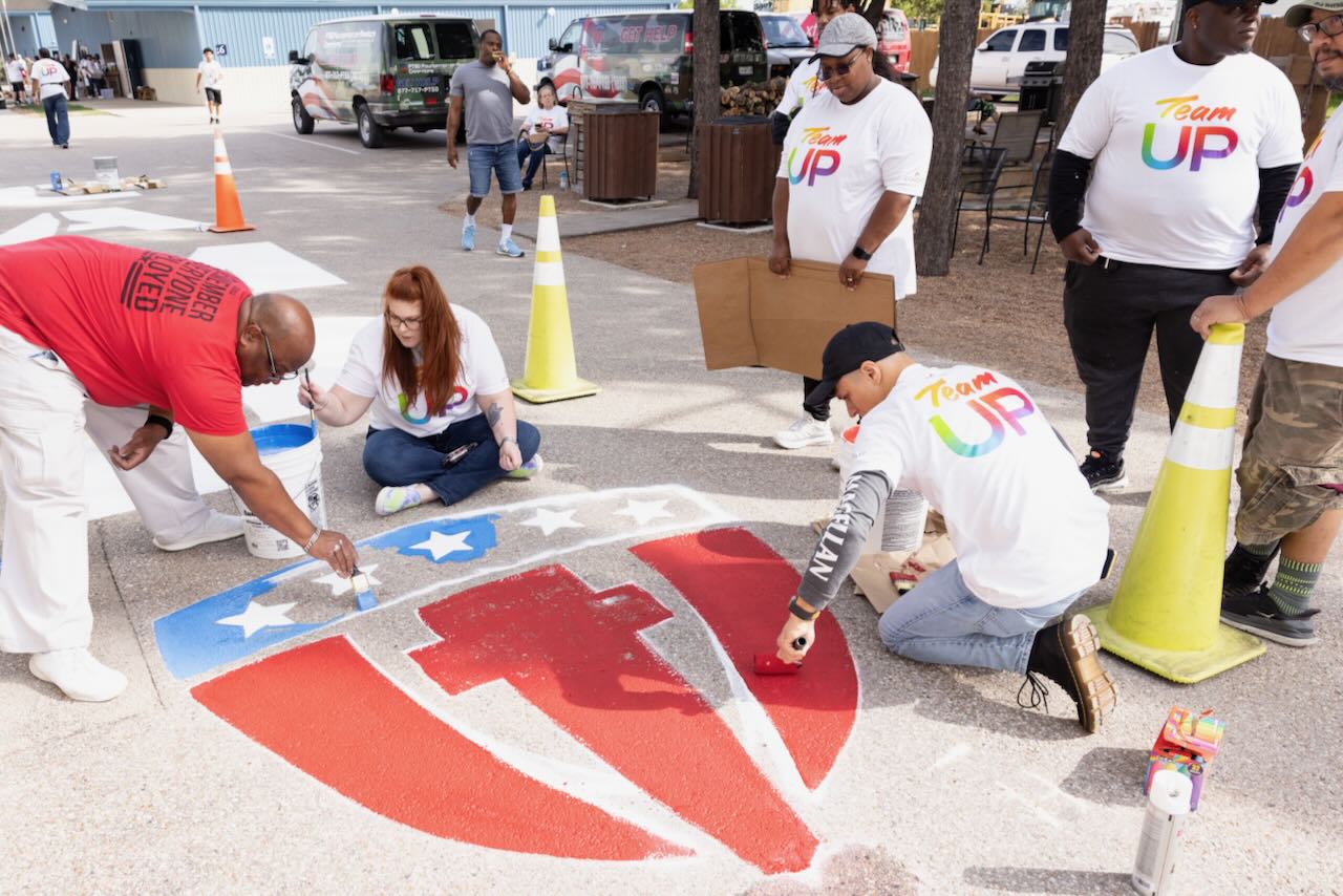 Volunteers with Team UP paint outside Camp Hope in Houston, Texas