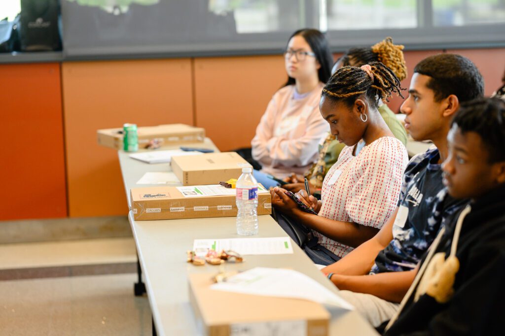 A student writes down resume building tips during the session.