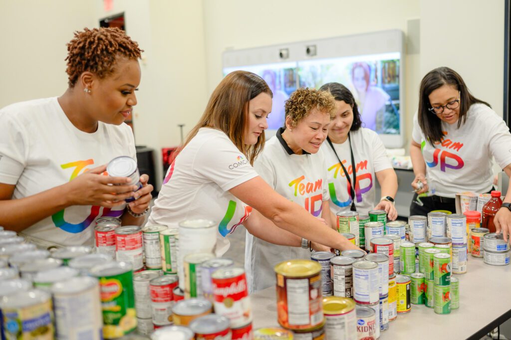 Volunteers help sort  through canned goods for Thanksgiving food drive.